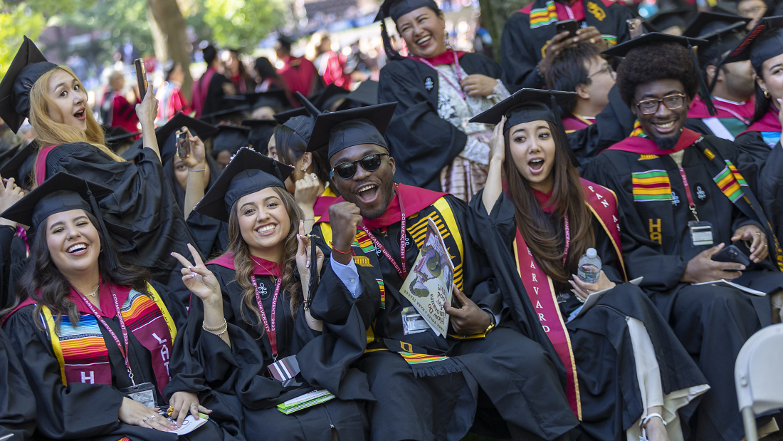 A group of HGSE grads pose and celebrate on a beautiful day