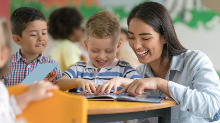 Teacher reading with happy young student