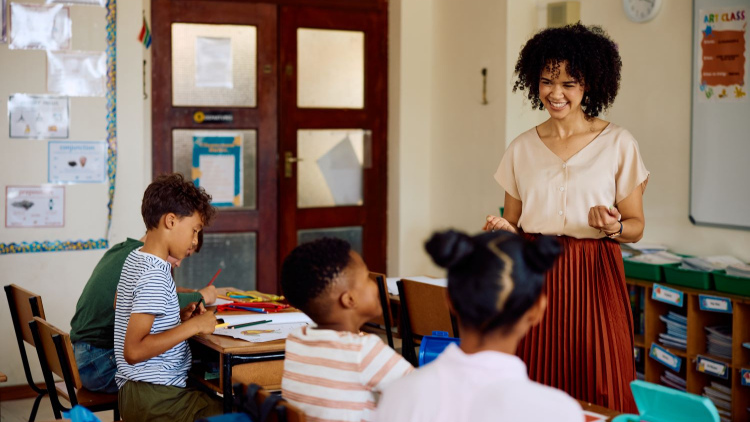 Elementary school teacher smiles while having a discussion with her class