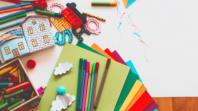 Children's art and buidling materials layed out on floor